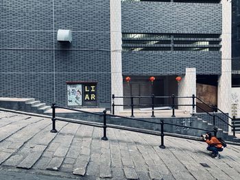 People walking on footpath against building