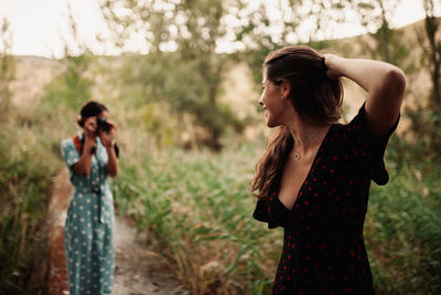 Lesbian couple standing by plants on land