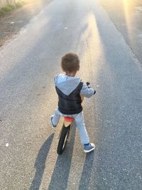 Rear view of boy on road