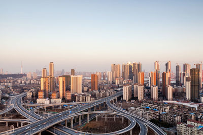 Road and buildings against clear sky in city