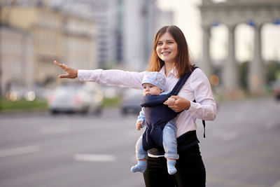 Portrait of smiling woman standing on street in city