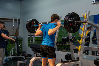 Young man preparing for squat at gym