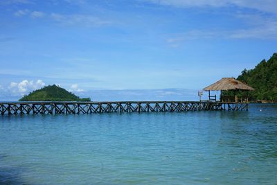 Pier over sea against blue sky