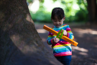 Young girl playing outdoor measure-mate in the forest park for leaning measurement