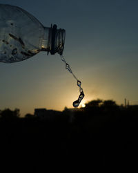 Close-up of silhouette chain against sky at sunset