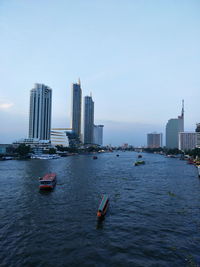 Scenic view of sea and buildings against clear sky