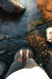 Low section of woman standing in river