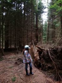 Full length of man standing on tree trunk in forest