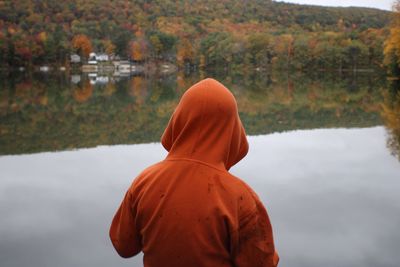 Rear view of man standing by lake