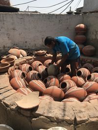 An indian traditional potter prepares water clay pots for firing.