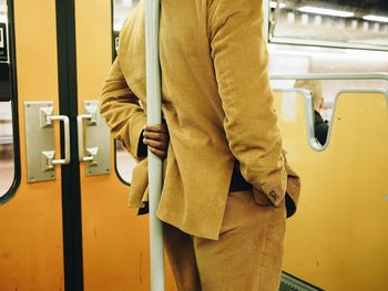 Rear view of men standing in train