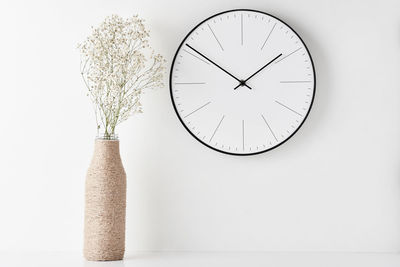 Close-up of clock on white wall
