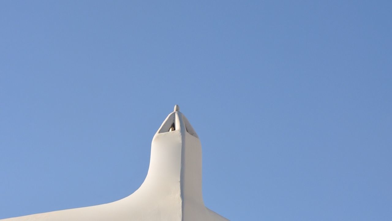 clear sky, copy space, low angle view, blue, high section, white color, part of, built structure, architecture, no people, white, day, outdoors, religion, sculpture, statue, building exterior, sunlight, spirituality, close-up