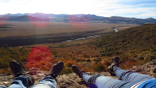 Low section of people on mountain against sky