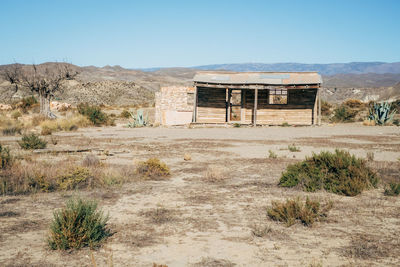 Abandoned built structure on landscape against clear sky