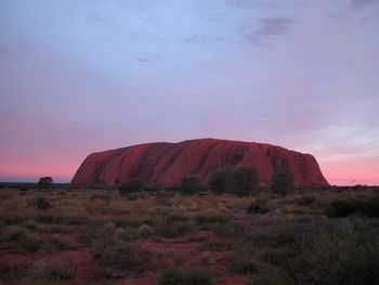 Rock formations on landscape against sky during sunset