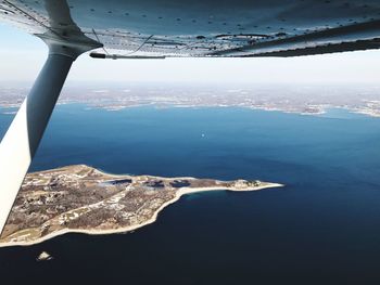 Aerial view of city by sea against sky