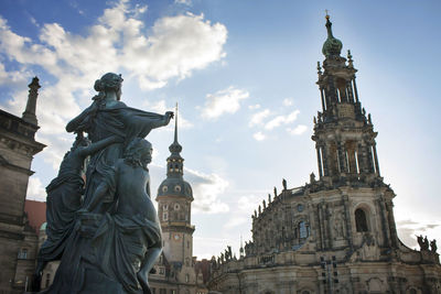 Low angle view of statue and buildings against sky