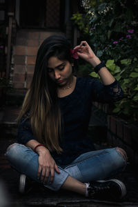 Beautiful young woman sitting outdoors