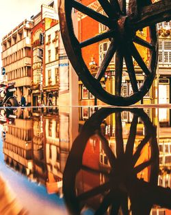 Close-up of illuminated wheel by building in city