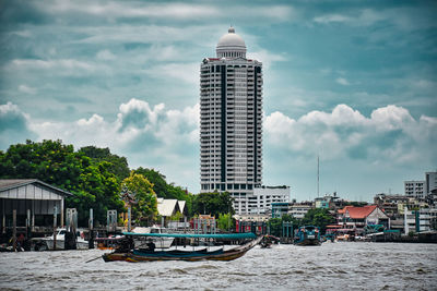 Ship in sea against buildings in city