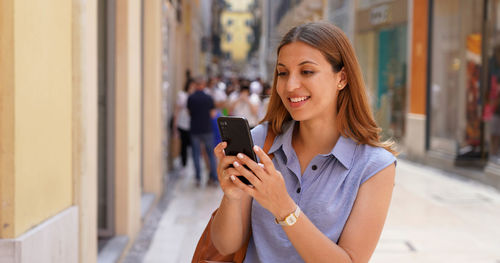 Panoramic banner of attractive busienss woman using mobile phone in the street