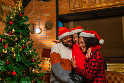 Rear view of woman with christmas tree at home