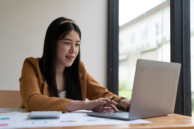 Young businesswoman using laptop at office