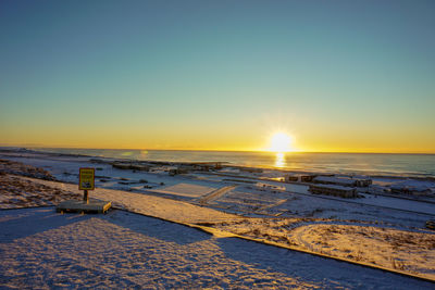 Scenic view of snow covered landscape against sky during sunset