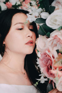 Close-up portrait of woman with pink flowers