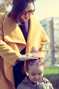 Rear view of mother with baby girl holding hands