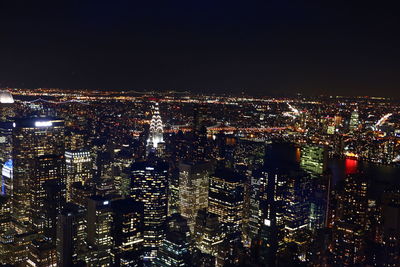 Illuminated cityscape against sky at night