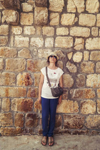 Woman standing against brick wall