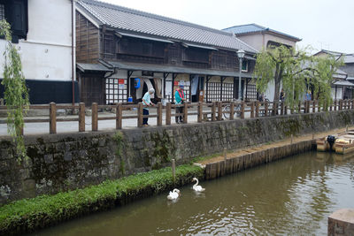 Canal by building in city