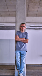 Portrait of young man standing against wall