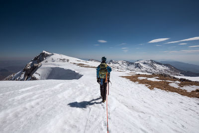 Man skiing on snowcapped mountain against sky