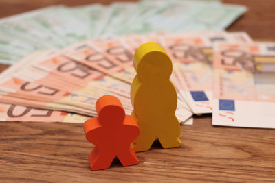 Close-up of figurines and paper currencies on table