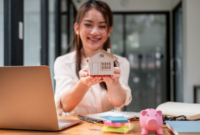 Portrait of young woman using laptop at home