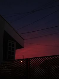 Low angle view of illuminated building against sky at sunset