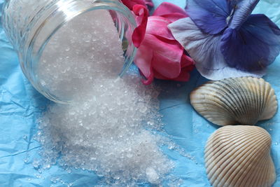 Close-up of bath salt by flowers on table