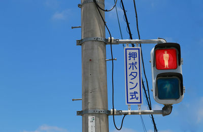 Low angle view of street signal light against clear blue sky