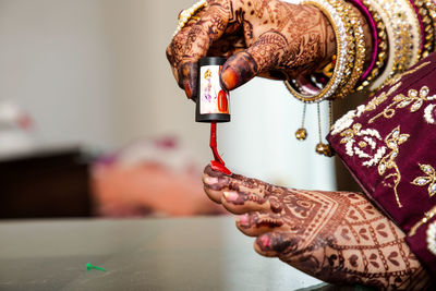 Cropped hand of woman using sewing machine