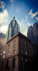 Low angle view of office building against cloudy sky