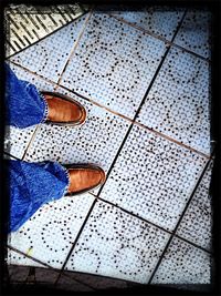 Low section of people standing on tiled floor