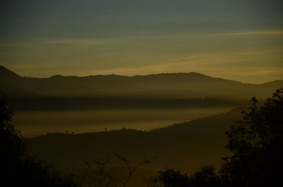 Scenic view of silhouette mountains against sky at sunset