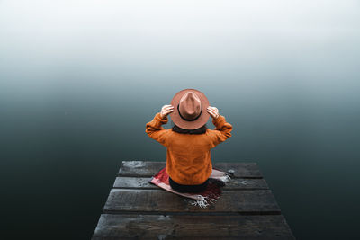 Rear view of woman standing against wall