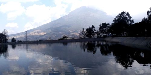 Scenic view of lake by mountains against sky