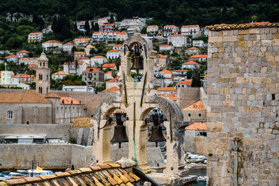 Bells on church against houses