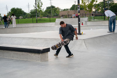 Full length of man playing with skateboard