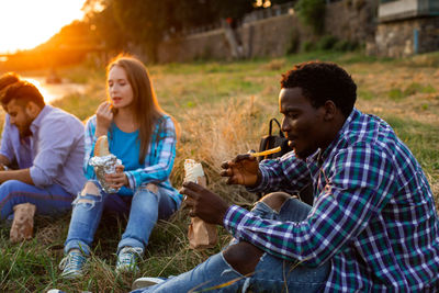 Side view of friends using mobile phone